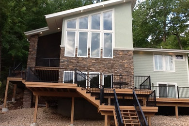 Large minimalist two-story stone exterior home photo in Other