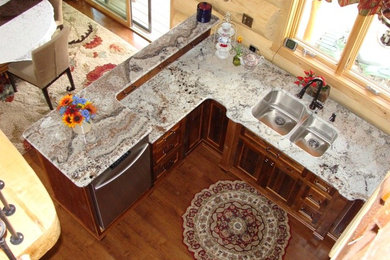 Example of a large classic u-shaped dark wood floor eat-in kitchen design in Minneapolis with a double-bowl sink, recessed-panel cabinets, dark wood cabinets, granite countertops, beige backsplash, stainless steel appliances and no island