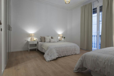 Modelo de dormitorio principal actual de tamaño medio sin chimenea con paredes grises, suelo de madera clara y suelo beige