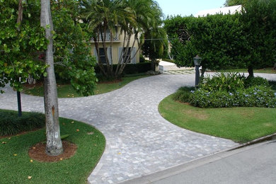 Photo of a large traditional front yard partial sun driveway in Miami with concrete pavers.