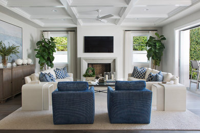 Photo of a beach style living room in Denver with grey walls, dark hardwood floors, a standard fireplace, a wall-mounted tv and brown floor.