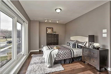 Photo of a mid-sized transitional guest bedroom in Toronto with brown walls, dark hardwood floors, no fireplace and brown floor.