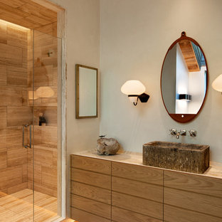 Rustikales Badezimmer mit flächenbündigen Schrankfronten, hellbraunen Holzschränken, Duschnische, grauer Wandfarbe, Aufsatzwaschbecken, braunem Boden, Falttür-Duschabtrennung und beiger Waschtischplatte in Sonstige