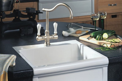 Small transitional single-wall kitchen pantry photo with a farmhouse sink, flat-panel cabinets, medium tone wood cabinets, granite countertops, an island and stainless steel appliances