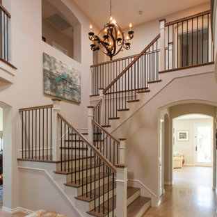 Modelo de escalera en U, tradicional, con escalones de madera, contrahuellas de madera pintada y barandilla de varios materiales