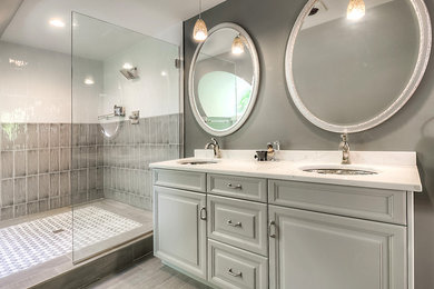 Mid-sized transitional master multicolored tile and ceramic tile ceramic tile doorless shower photo in New York with raised-panel cabinets, gray cabinets, a two-piece toilet, gray walls, an undermount sink, quartz countertops and white countertops