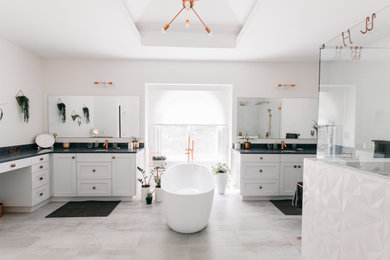 This is an example of a large modern master bathroom in Atlanta with white cabinets, a freestanding tub, a corner shower, white tile, ceramic tile, an undermount sink, engineered quartz benchtops, a hinged shower door, a shower seat, a double vanity and grey benchtops.