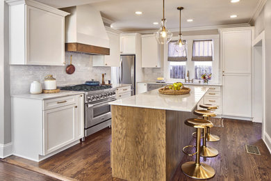Eat-in kitchen - mid-sized modern galley medium tone wood floor, brown floor and tray ceiling eat-in kitchen idea in Dallas with an integrated sink, shaker cabinets, white cabinets, quartzite countertops, white backsplash, ceramic backsplash, stainless steel appliances, an island and white countertops