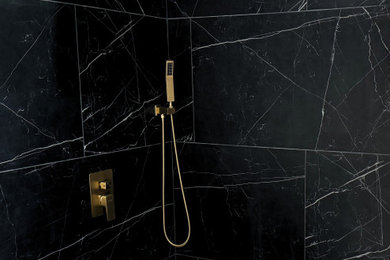 Modelo de cuarto de baño principal actual con baldosas y/o azulejos negros, ducha empotrada y paredes negras