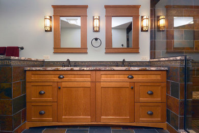 Photo of a large arts and crafts master bathroom in Chicago with recessed-panel cabinets, medium wood cabinets, a corner shower, a two-piece toilet, multi-coloured tile, stone tile, slate floors, an undermount sink and granite benchtops.