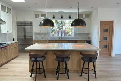 Kitchen pantry - large modern light wood floor and brown floor kitchen pantry idea in San Francisco with an integrated sink, flat-panel cabinets, light wood cabinets, quartzite countertops, white backsplash, ceramic backsplash, stainless steel appliances, an island and gray countertops