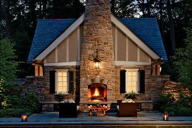Example of a brown one-story stone gable roof design in New York