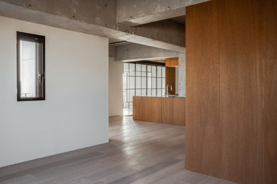 Imagen de comedor gris contemporáneo abierto con paredes marrones y suelo de madera clara