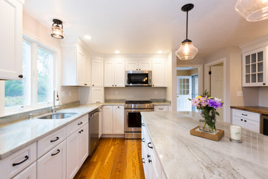Inspiration for a light wood floor kitchen remodel in Boston with shaker cabinets, white cabinets, stainless steel appliances and an island