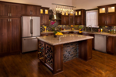 Large elegant l-shaped medium tone wood floor open concept kitchen photo in San Diego with an undermount sink, raised-panel cabinets, dark wood cabinets, quartz countertops, brown backsplash, mosaic tile backsplash, stainless steel appliances and an island