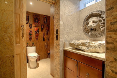 Inspiration for a large mediterranean master gray tile and stone tile pebble tile floor and beige floor bathroom remodel in Toronto with shaker cabinets, dark wood cabinets, a one-piece toilet, beige walls, a vessel sink, granite countertops and white countertops