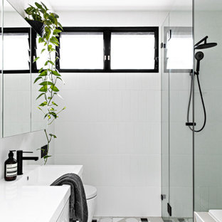 Inspiration for a small scandinavian master bathroom in Sydney with white cabinets, a drop-in tub, a one-piece toilet, white tile, ceramic tile, white walls, ceramic floors, a wall-mount sink, grey floor, a hinged shower door and white benchtops.