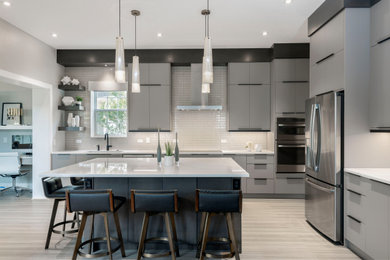 Inspiration for a large contemporary l-shaped open plan kitchen in Orlando with flat-panel cabinets, grey cabinets, ceramic splashback, stainless steel appliances and with island.