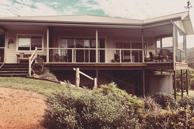 Diseño de fachada de casa beige de estilo de casa de campo de tamaño medio de una planta con revestimiento de aglomerado de cemento, tejado a dos aguas y tejado de metal