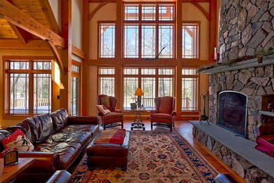 This is an example of a mid-sized traditional formal open concept living room in Manchester with beige walls, medium hardwood floors, a standard fireplace, a stone fireplace surround, no tv and brown floor.