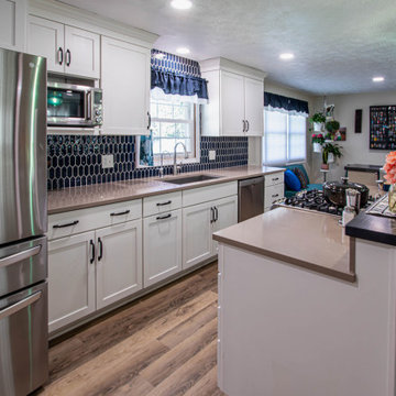 White Kitchen with Blue Tiled Backsplash and Two Tier Island