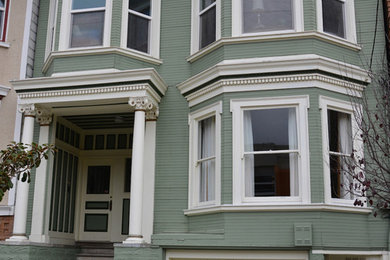 Photo of a mid-sized traditional two-storey green exterior in San Francisco with wood siding and a flat roof.