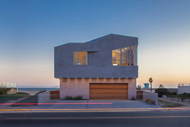 Photo of a large contemporary two-storey concrete grey house exterior in Los Angeles with a hip roof.