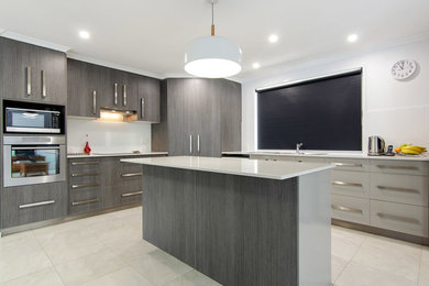 Photo of a mid-sized modern l-shaped eat-in kitchen in Brisbane with a double-bowl sink, flat-panel cabinets, dark wood cabinets, granite benchtops, white splashback, glass sheet splashback, stainless steel appliances, ceramic floors and with island.