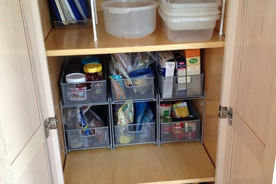 Mid-sized elegant single-wall ceramic tile kitchen pantry photo in New York with raised-panel cabinets and light wood cabinets