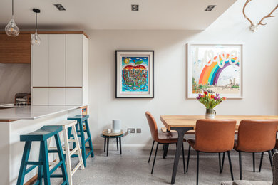 Design ideas for a contemporary dining room in Surrey with white walls and grey floor.