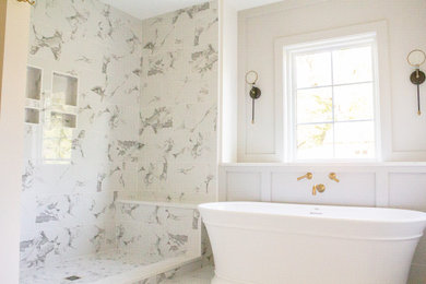 Inspiration for a large transitional master bathroom in St Louis with flat-panel cabinets, blue cabinets, a freestanding tub, white tile, marble, white walls, marble floors, a drop-in sink, engineered quartz benchtops, white floor, a hinged shower door and white benchtops.
