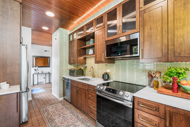 Small 1960s galley concrete floor, orange floor and wood ceiling enclosed kitchen photo in Other with an undermount sink, flat-panel cabinets, dark wood cabinets, quartz countertops, green backsplash, subway tile backsplash, stainless steel appliances, a peninsula and white countertops