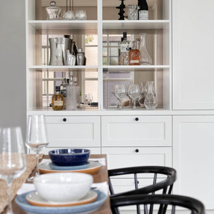 Immagine di una grande sala da pranzo aperta verso il soggiorno stile marinaro con pareti bianche, parquet chiaro, pavimento beige e soffitto in perlinato
