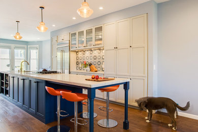 Mid-sized transitional single-wall open plan kitchen in San Francisco with an undermount sink, recessed-panel cabinets, blue cabinets, marble benchtops, multi-coloured splashback, porcelain splashback, stainless steel appliances, medium hardwood floors, with island, brown floor and white benchtop.