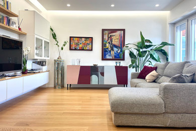 Immagine di un grande soggiorno minimal stile loft con pareti bianche, parquet chiaro, parete attrezzata e soffitto ribassato