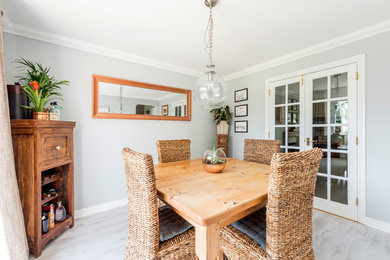 Small country separate dining room in Dorset with grey walls, laminate floors and grey floor.