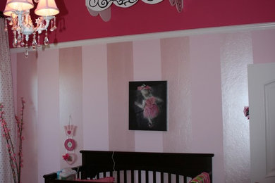 Inspiration for a mid-sized contemporary girl carpeted and beige floor nursery remodel in Albuquerque with pink walls