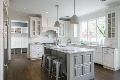 Eat-in kitchen - large transitional u-shaped dark wood floor and brown floor eat-in kitchen idea in New York with an undermount sink, recessed-panel cabinets, granite countertops, white backsplash, marble backsplash, stainless steel appliances, an island and white cabinets