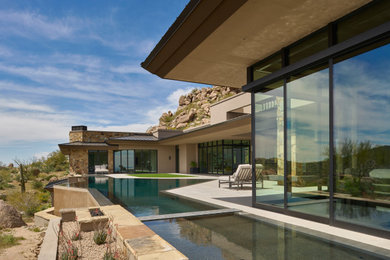 Inspiration for a huge contemporary backyard stone and custom-shaped infinity and privacy pool remodel in Phoenix