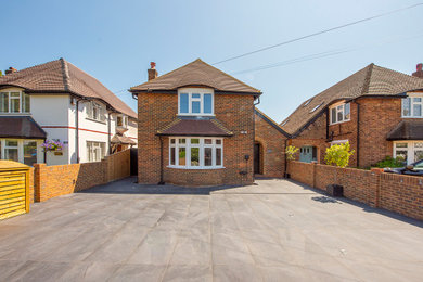 Large and brown contemporary two floor brick and front house exterior in London with a pitched roof, a tiled roof and a brown roof.