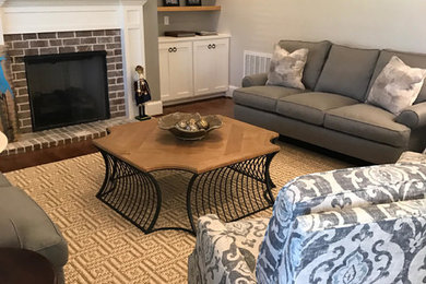 Example of a mid-sized classic open concept and formal dark wood floor and brown floor living room design in Orange County with a standard fireplace, beige walls, a brick fireplace and a wall-mounted tv