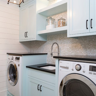 Bild på en maritim svarta linjär svart tvättstuga enbart för tvätt, med skåp i shakerstil, blå skåp, en undermonterad diskho, vita väggar och flerfärgat golv