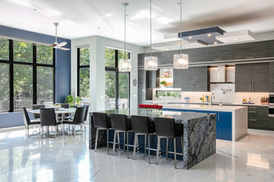 Example of a large trendy l-shaped ceramic tile and white floor open concept kitchen design in St Louis with an undermount sink, flat-panel cabinets, gray cabinets, granite countertops, white backsplash, stone slab backsplash, paneled appliances, two islands and white countertops