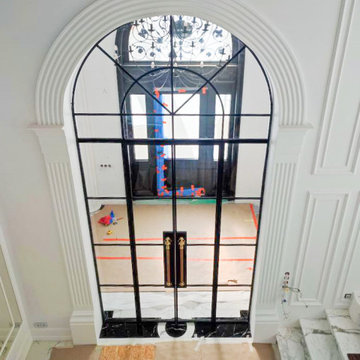 Tall arched Steel entrance Doors to the living room with golden handles