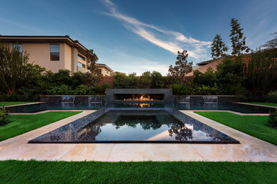 Hot tub - small modern backyard custom-shaped infinity hot tub idea in Las Vegas