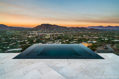 Example of a large minimalist pool design in Phoenix with decking