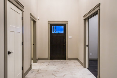 Huge trendy porcelain tile entryway photo in Calgary with beige walls and a brown front door
