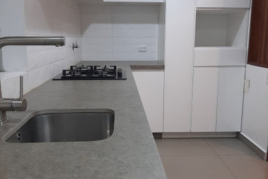 Inspiration for a small modern galley ceramic tile and gray floor eat-in kitchen remodel in Chicago with a single-bowl sink, flat-panel cabinets, white cabinets, quartz countertops, white backsplash, subway tile backsplash, stainless steel appliances, no island and gray countertops