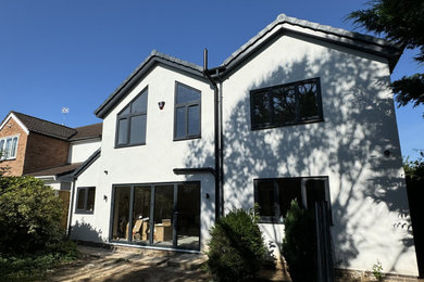 Inspiration for a white modern render and rear house exterior in Other with a pitched roof.