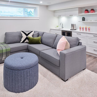 Small traditional open plan home cinema in Vancouver with white walls, laminate floors, a wall mounted tv and brown floors.
